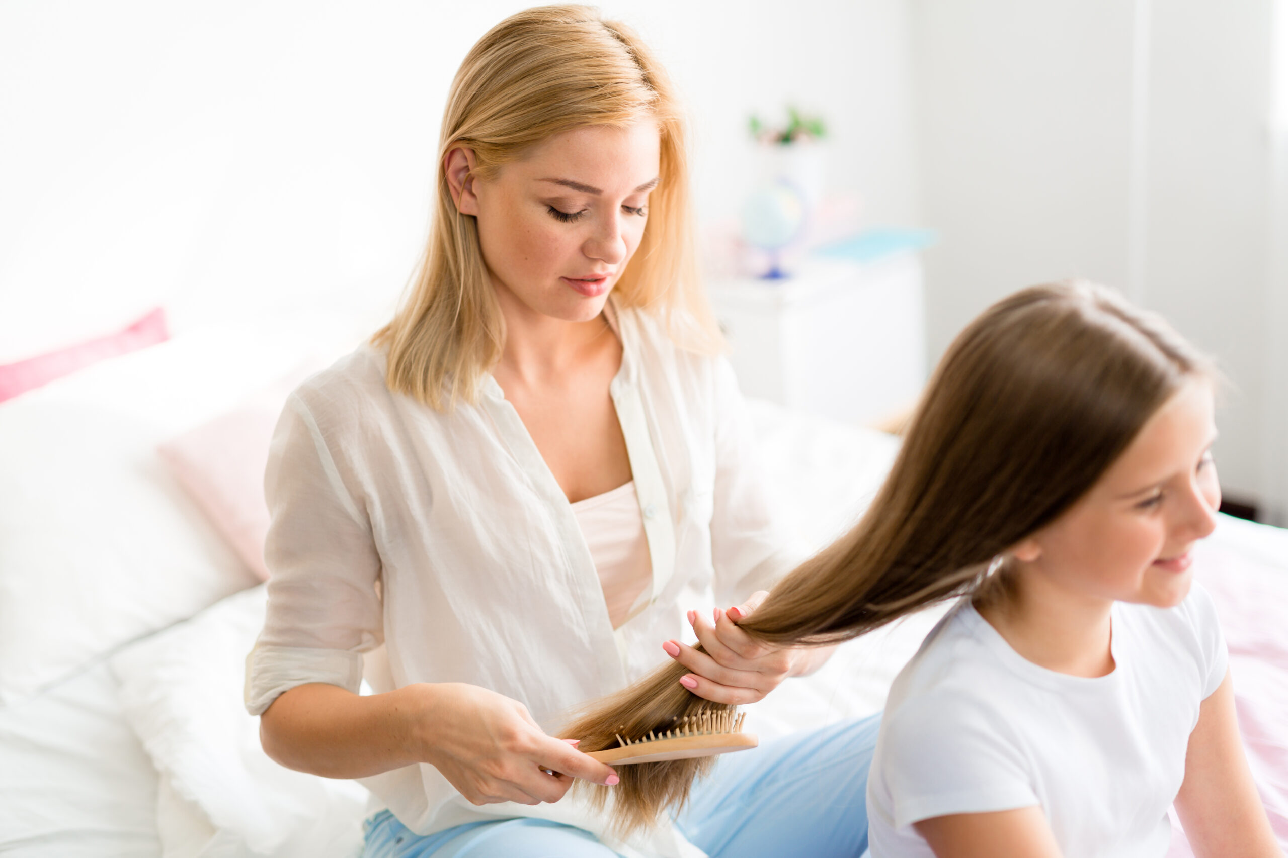 Mutter bürstet ihrer Tochter die Haare